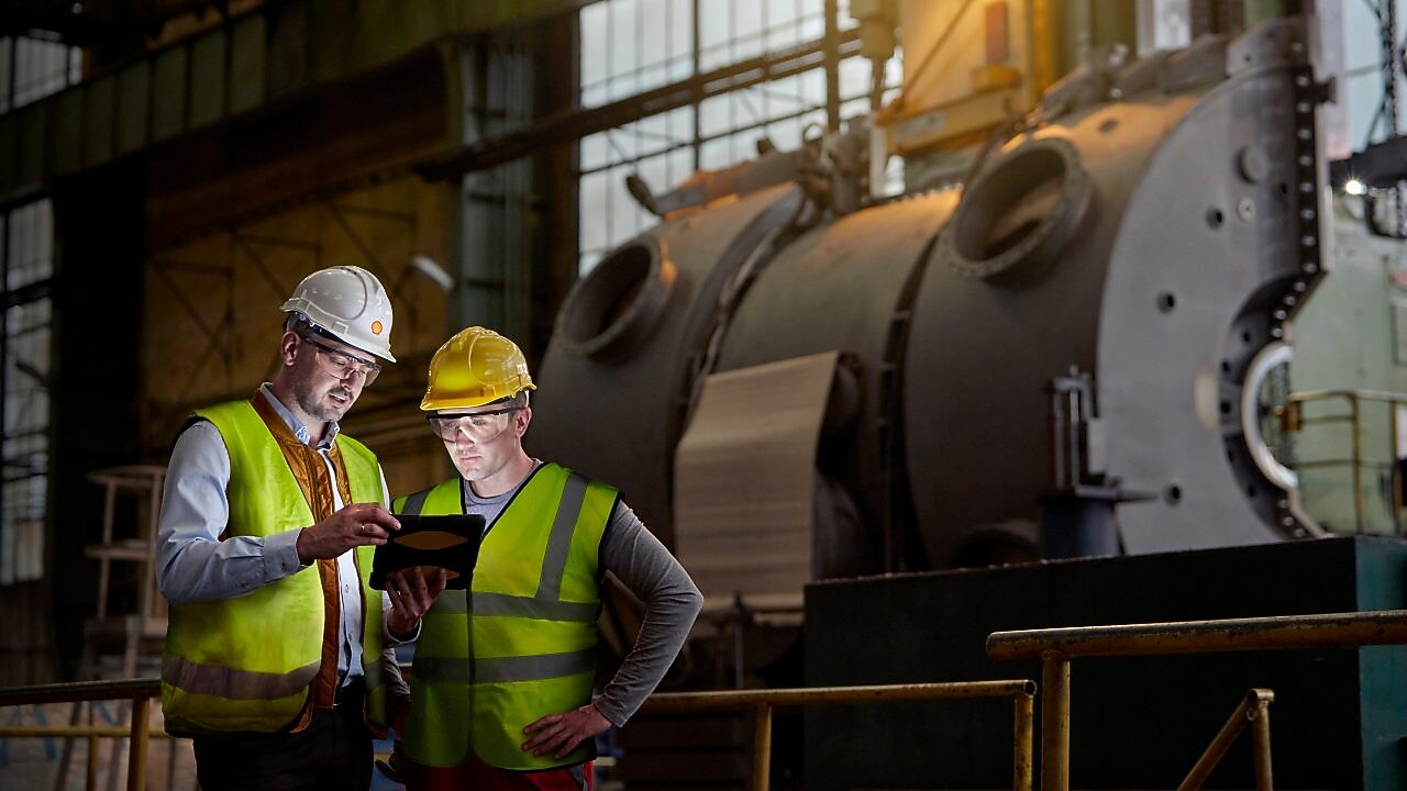 Shell worker consulting an industry worker on site