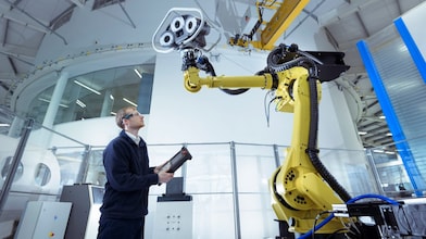 Engineer with robot in robotics research facility