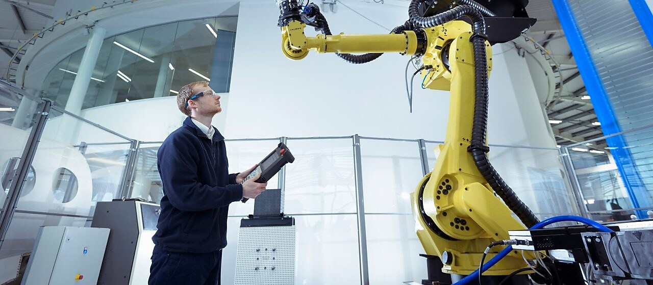 Engineer with robot in robotics research facility