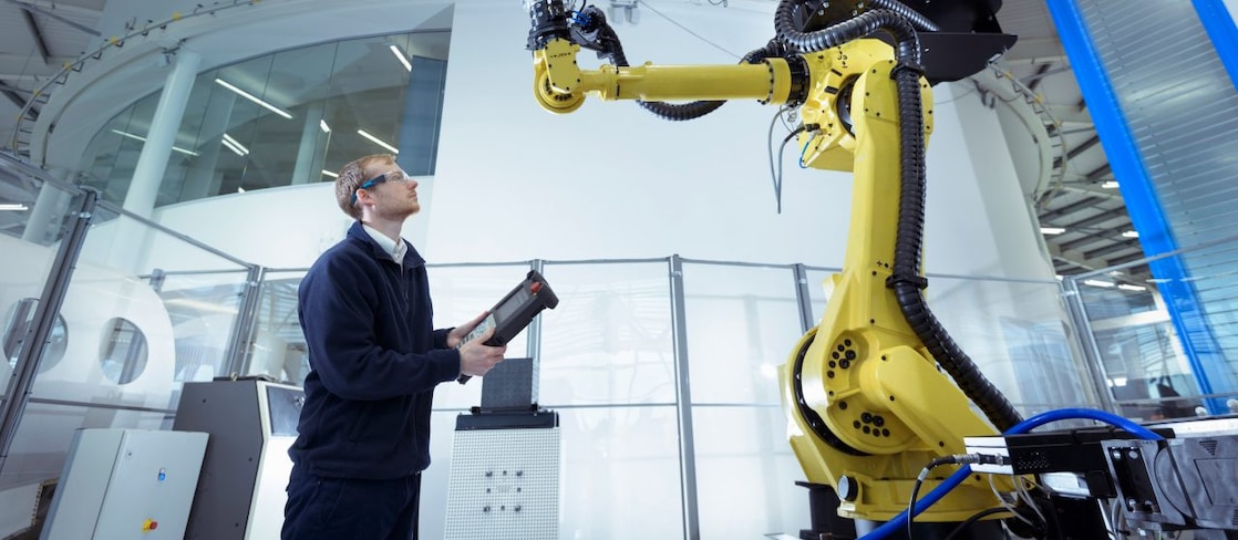 Engineer with robot in robotics research facility