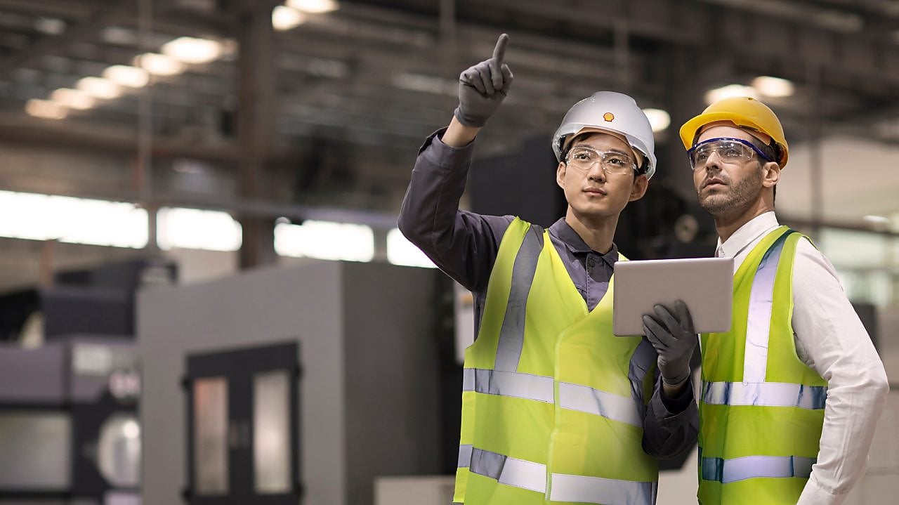 Shell worker consulting an industry worker on site