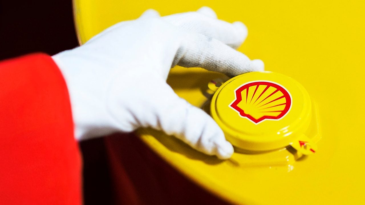 A Shell expert adjusts the lid of a barrel of lubricant displaying the Shell logo