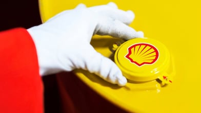 A Shell expert adjusts the lid of a barrel of lubricant displaying the Shell logo
