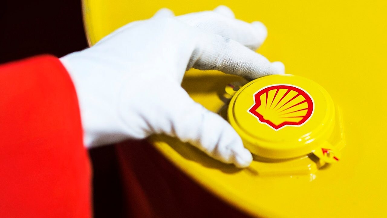 A Shell expert adjusts the lid of a barrel of lubricant displaying the Shell logo