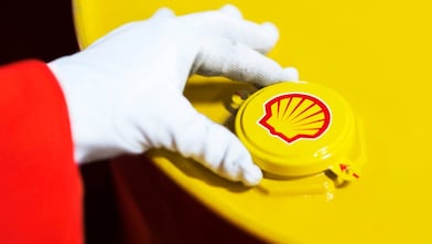 A Shell expert adjusts the lid of a barrel of lubricant displaying the Shell logo