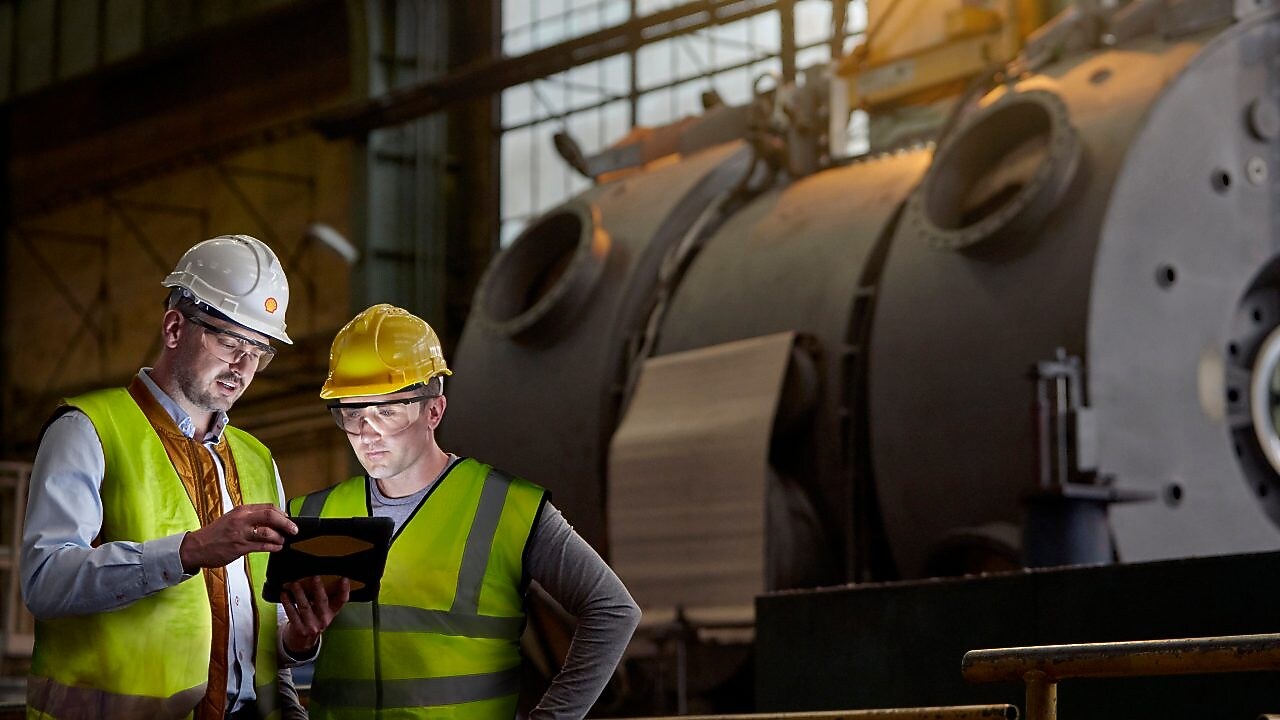 Shell worker consulting an industry worker on site