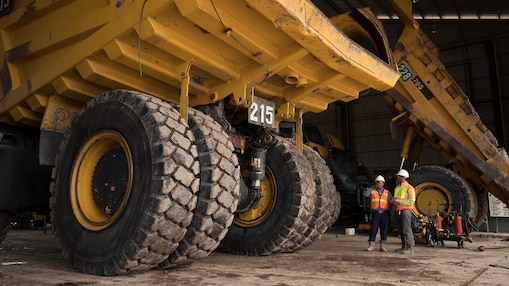 Two engineers in front of dump truck