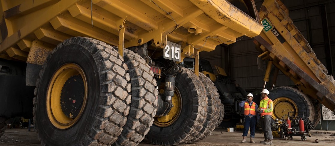 Two engineers in front of dump truck