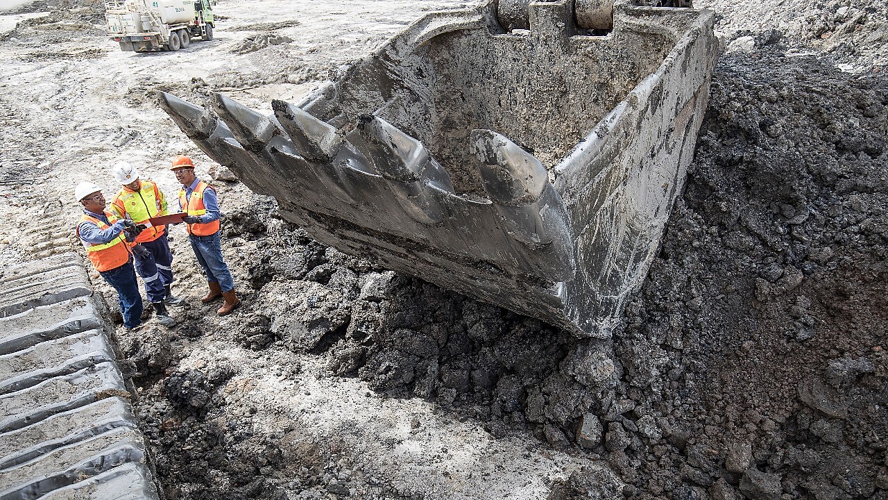 3 engineers next to digger