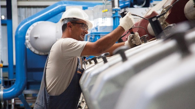 Worker doing maintenance work on a stationary gas engine