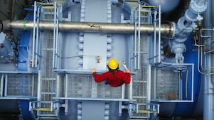 Worker inspecting valve at power station