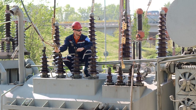 Electrician checking electricity transformer equipment.
