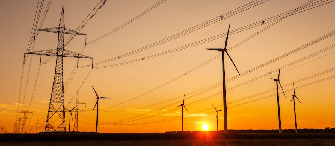 Pylons and wind turbines in the sunset