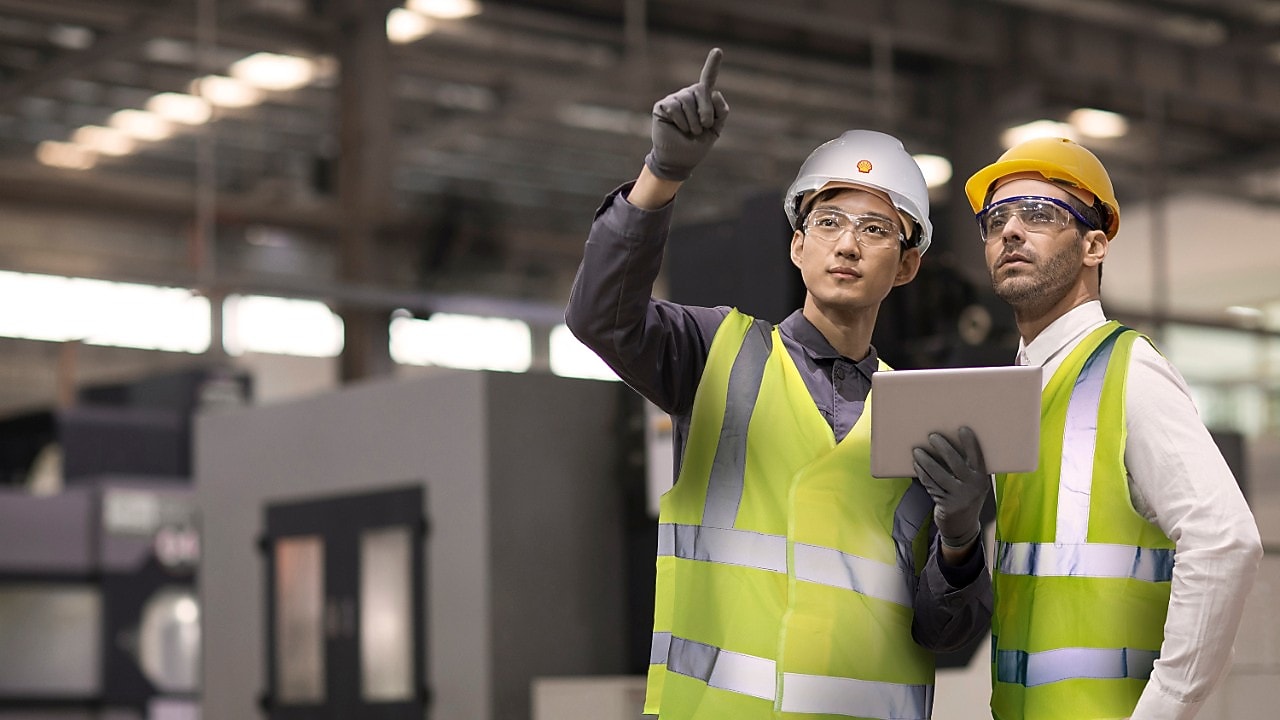 Shell worker consulting an industry worker on site