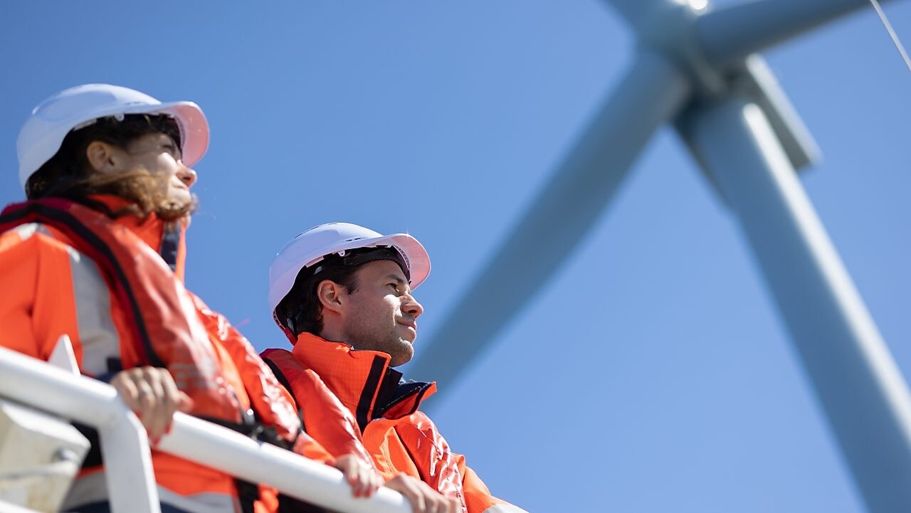 Wind technician standing outside of wind turbine