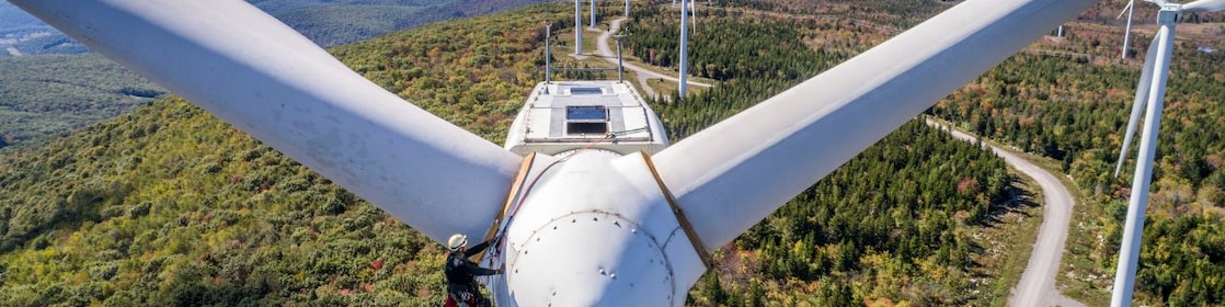 Wind technician scaling wind turbine