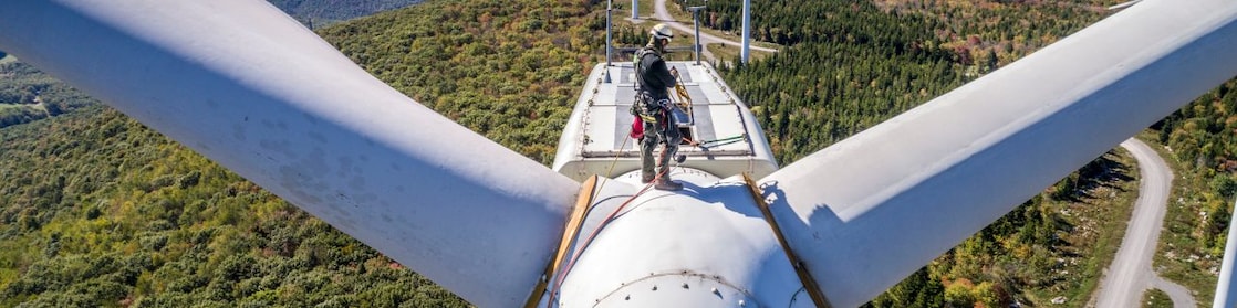Wind technician scaling wind turbine