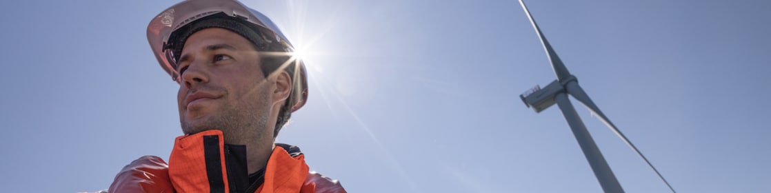 Wind technician standing outside of wind turbine