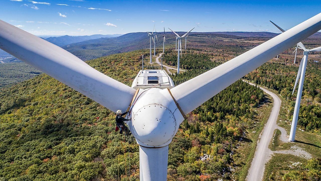 Wind technician scaling wind turbine
