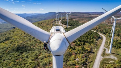 Wind technician scaling wind turbine