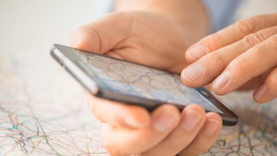 Close-up of hand using smartphone over map