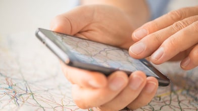 Close-up of hand using smartphone over map