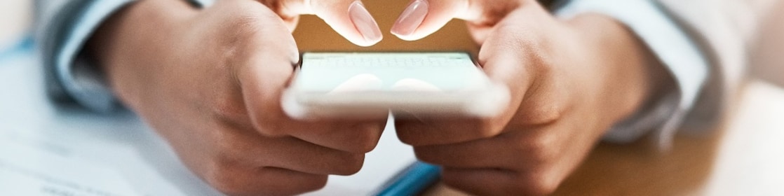 Two hands shown using a mobile device to send an email