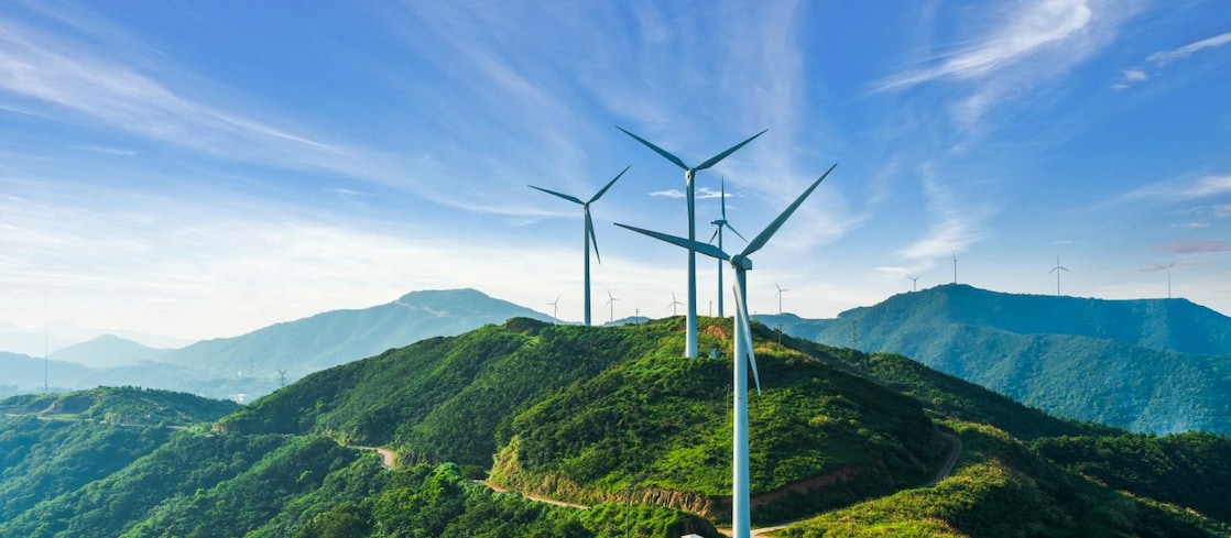 Mountainous landscape with wind turbines scattered across