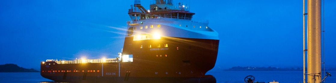 Bow view of cargo ship sailing out of port.