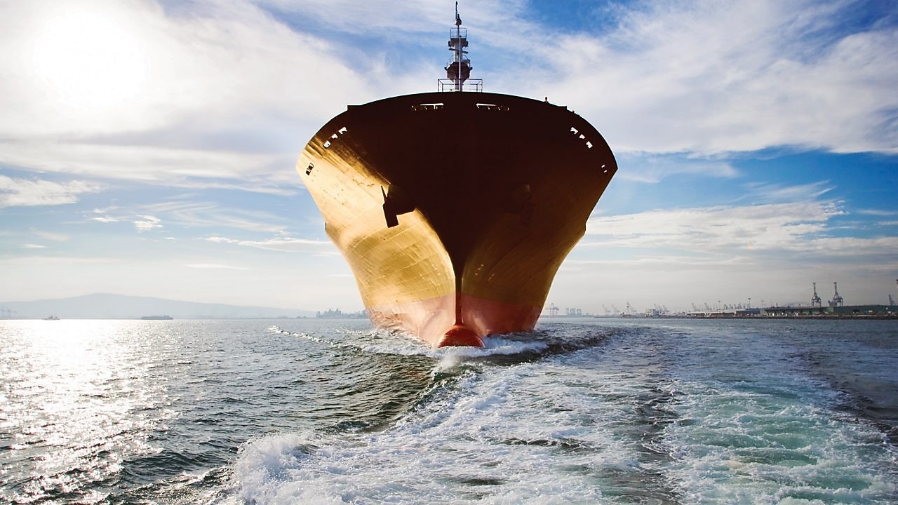 Bow view of cargo ship sailing out of port.