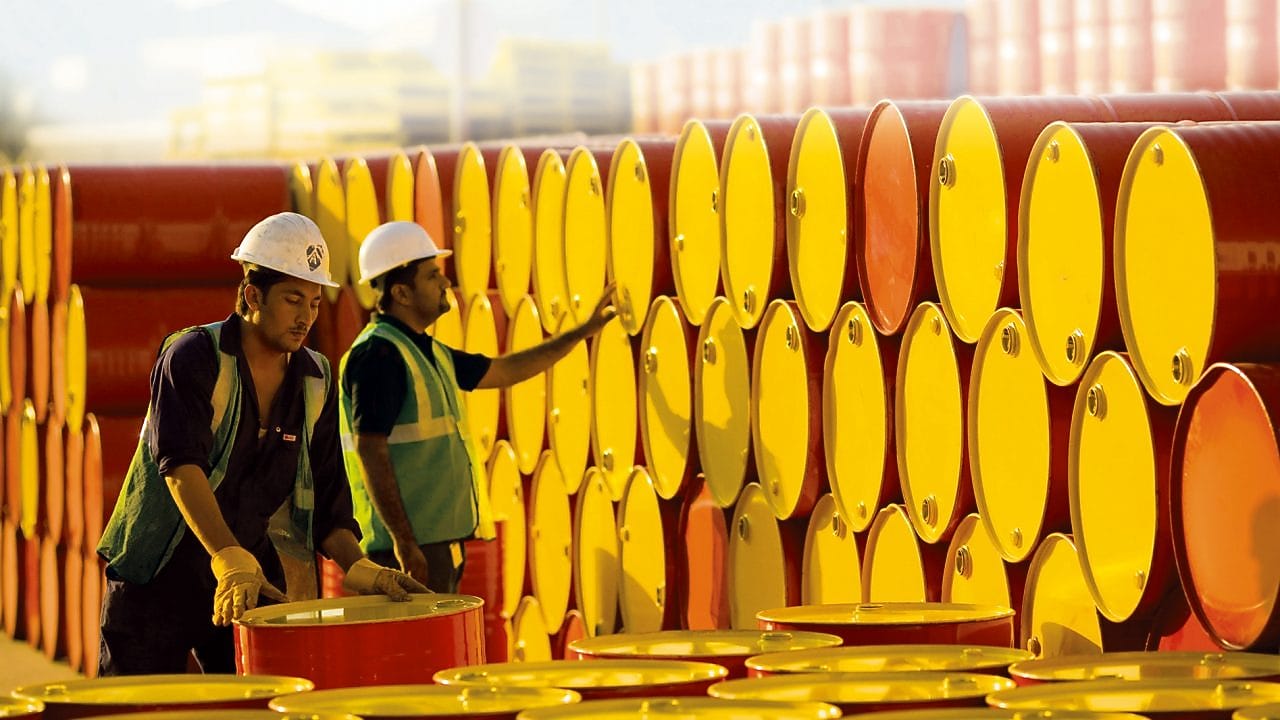 A white gloved hand tightening a Shell logo fuel cap