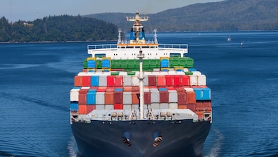 Refuelling a tanker from a tug on the Houston shipping channel, USA