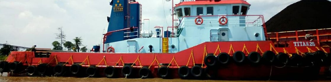 Bow view of loaded cargo ship sailing out of port.