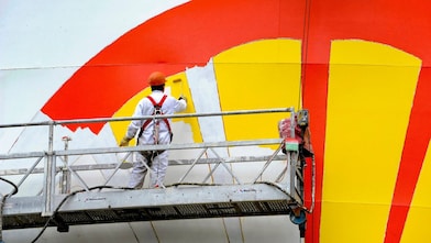 Shell Pecten being painted by a worker