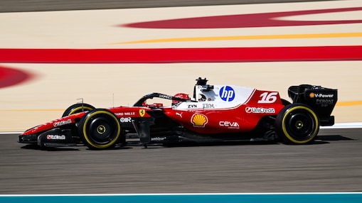 Ferrari Formula 1 car with Shell, HP, and UniCredit branding racing along a track with red and cream barrier patterns in the background.