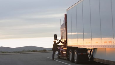 driver climbing up into the cab of his truck