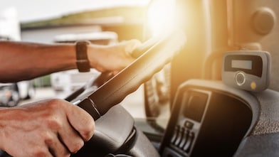 driver's hands on the steering wheel in a truck cab