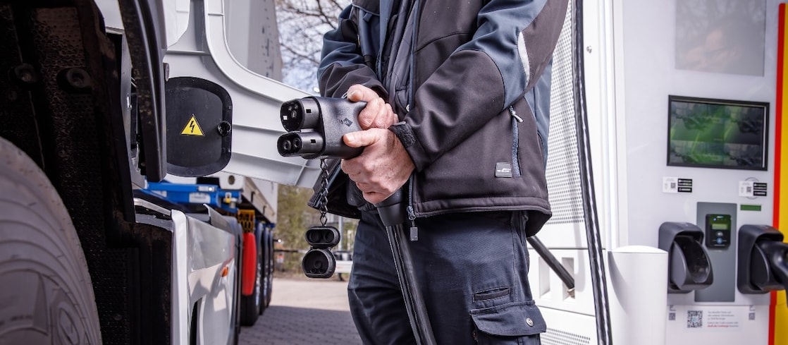 Driver plugging in truck to charge