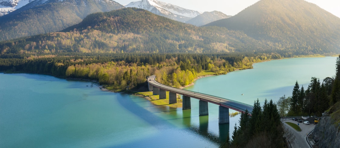 Birds eye view of river with a bridge with “Destination: Carbon Compensation” pointer