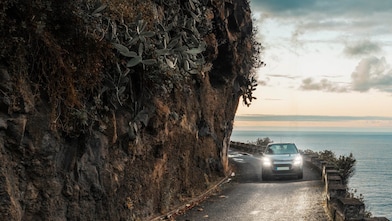  Car driving on a cliff road with the sea on the right