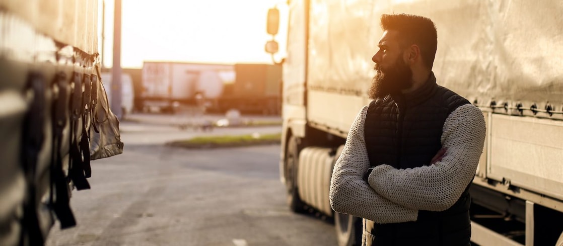 HGV driver folding arms looking at a truck 