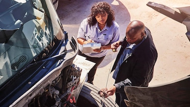 Workers talking next to a truck engine