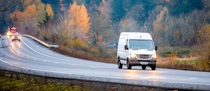 White van driving on wet road