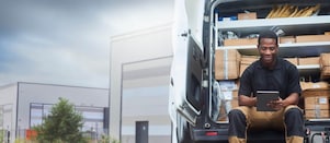 Delivery driver on tablet sat in van