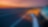 white car driving into sunset