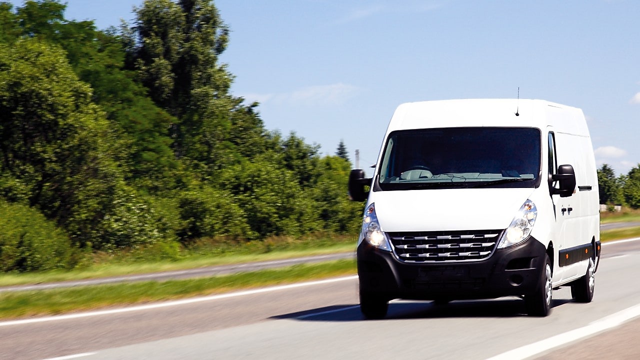 A white van driving down an open road
