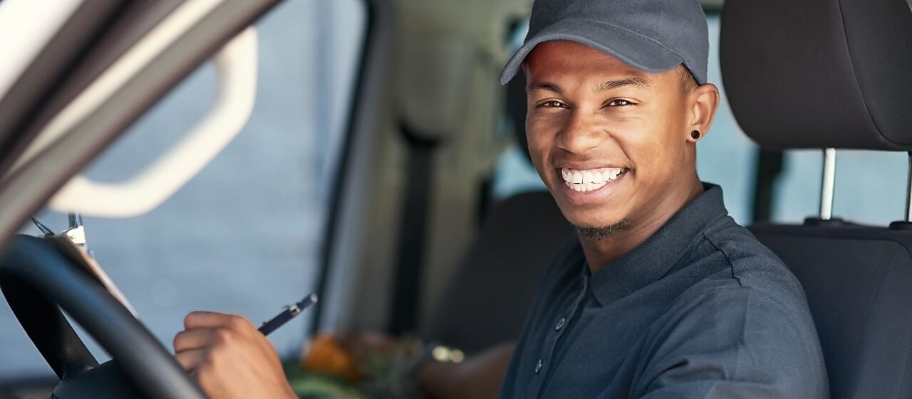 Man with a cap smiling in a car