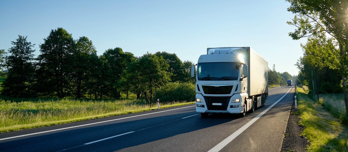 White lorry drives down country lane