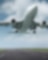 Airplane taking off from a runway, captured from below with landing gear still extended against a blue sky with clouds.