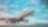 A large commercial airplane taking off from an airport runway with a partly cloudy sky at sunset in the background.